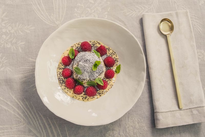 Geeister Germknödel mit Vanillesauce, Himbeeren und Mohn