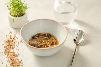 Gemüse-Dashi mit Buchweizen-Raviolo, sauren Buchenpilzen und gepufftem Buchweizen